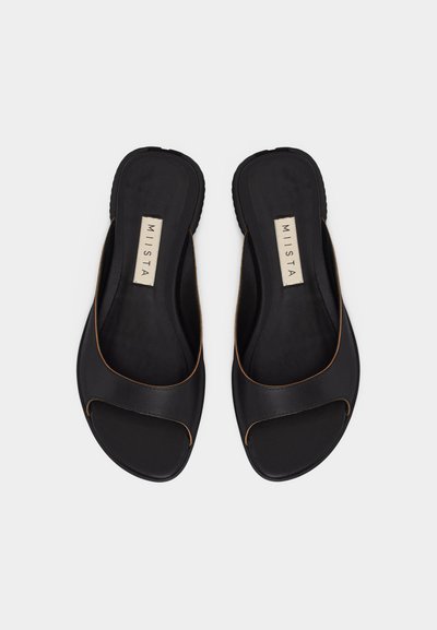 Ζευγάρι μαύρων ανοιχτών σανδαλιών τύπου slides με φαρδιές λουρίδες και ετικέτα "MIISTA" στις μαλακές εσωτερικές σόλες, απεικονιζόμενα από πάνω σε λευκό φόντο.