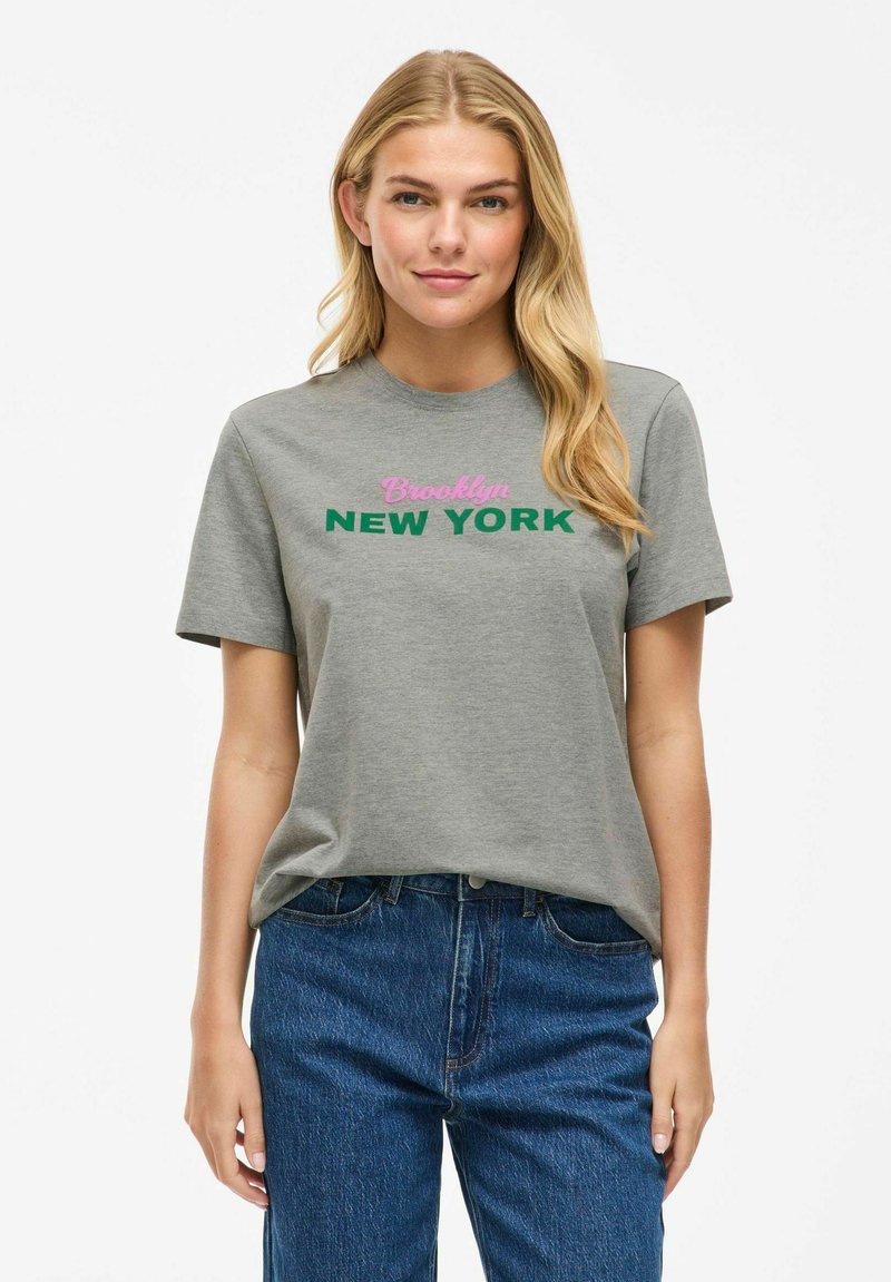 Grå bomullströja med korta ärmar som har rosa texten "Brooklyn" och grön texten "NEW YORK". Avslappnad design med rund halsringning.