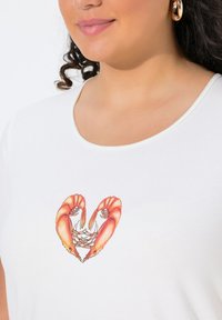 Bílá košile s barevným grafickým motivem srdce z krevety na přední straně, z hladkého materiálu a s kulatým výstřihem.