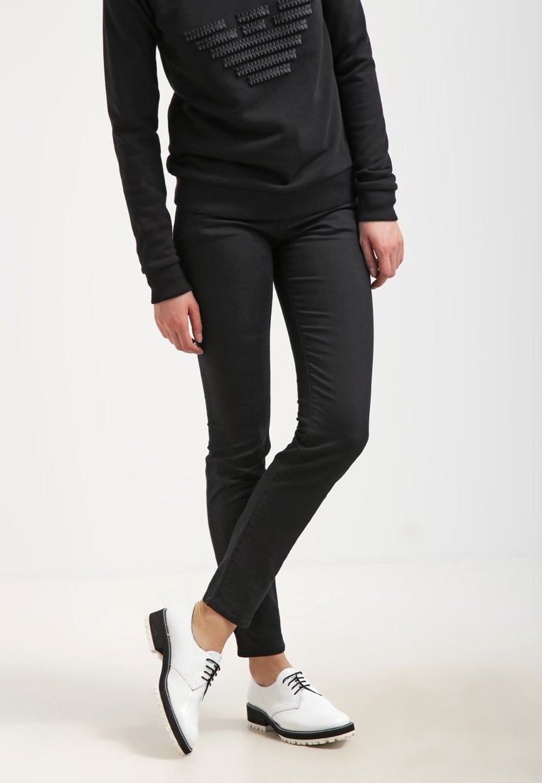 Svart sweatshirt med texturerat hjärtdesign och matchande svarta slim-fit byxor. Vita snörskor med svarta detaljer och en texturerad sula.