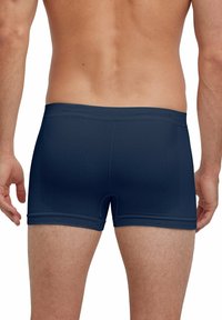 Boxer-briefs pour hommes bleu marine en tissu lisse, avec une coupe ajustée, une ceinture élastique et un détail subtil sur le panneau latéral.
