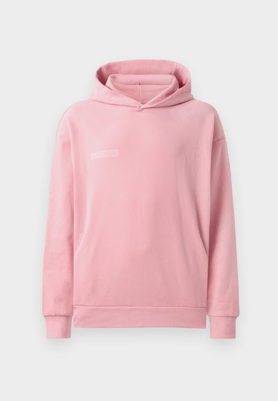 Hoodie rose avec une poche avant, capuche à cordon, et un petit texte imprimé en blanc sur le haut à gauche de la poitrine. Matière en coton douce, coupe décontractée.