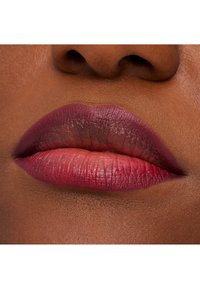 Leppermakeup med en gradient av dyp burgunder og myke rosa nyanser. Jevn tekstur med synlige leppecirkler og en naturlig glans.