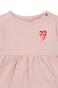 Robe courte à manches courtes rose clair avec une jupe froncée. Présente un détail de cœur rouge brodé et une fermeture à bouton à l'épaule.