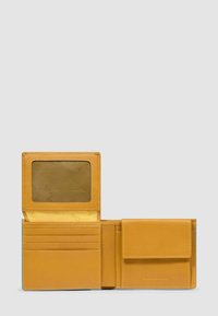 Portafoglio bifold in pelle color cuoio con tasca trasparente per tesserino, quattro scomparti per carte e portamonete con chiusura a patta, su sfondo grigio.