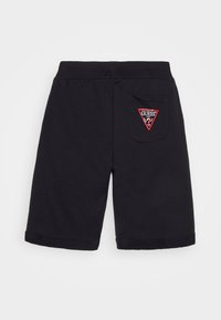 Shorts de algodón negros con cinturilla plana, puños enrollados y un bolsillo trasero con un logo triangular rojo de "GUESS".