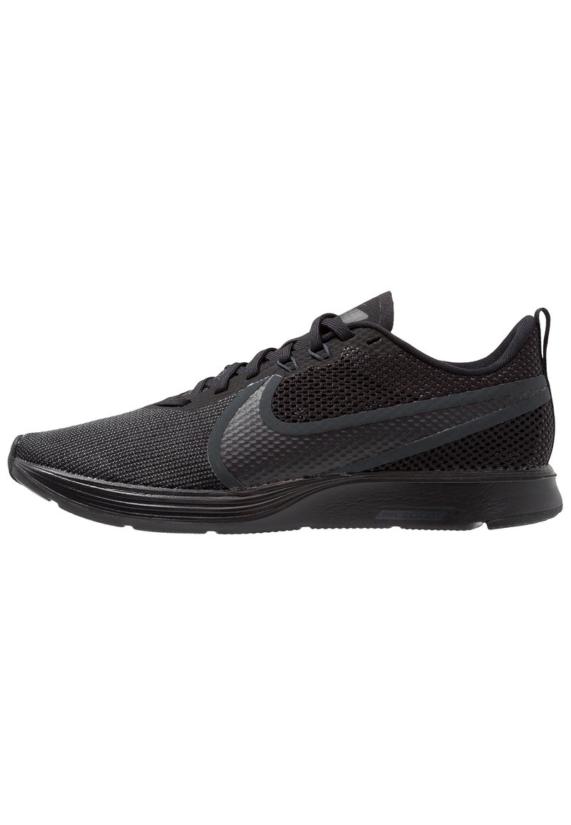 Chaussures de sport noires avec un dessus en maille, motif texturé et accents synthétiques. Présente une semelle épaisse et un bout arrondi pour le soutien.