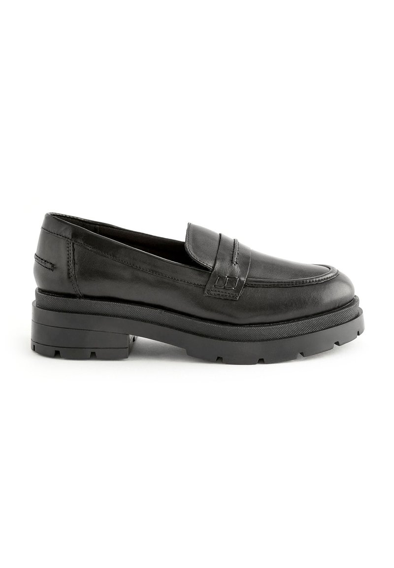 Mocassins en cuir noir avec un bout arrondi, des coutures décoratives et une semelle noire épaisse et texturée. Conçus avec un accent classique de sangle à pièce.