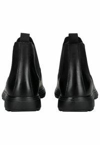 Botas de tobillo de cuero negro con un acabado suave, paneles laterales elásticos y suelas de goma texturizadas, con un diseño minimalista.