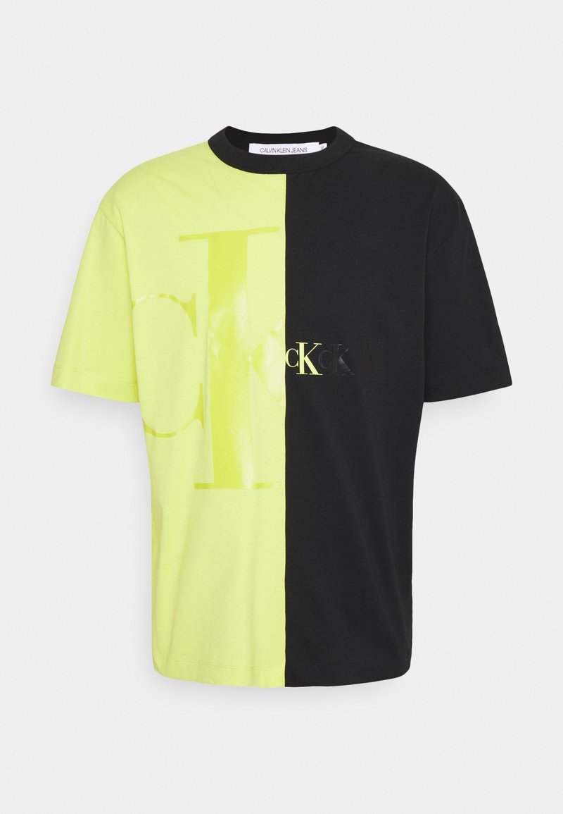 Camiseta de color bloqueada en amarillo neón y negro de algodón, con una gran impresión del logo. Manga corta, cuello redondo, ajuste relajado.