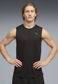 Débardeur de sport noir en tissu lisse avec un col rond. Présente un petit logo argenté sur la poitrine.