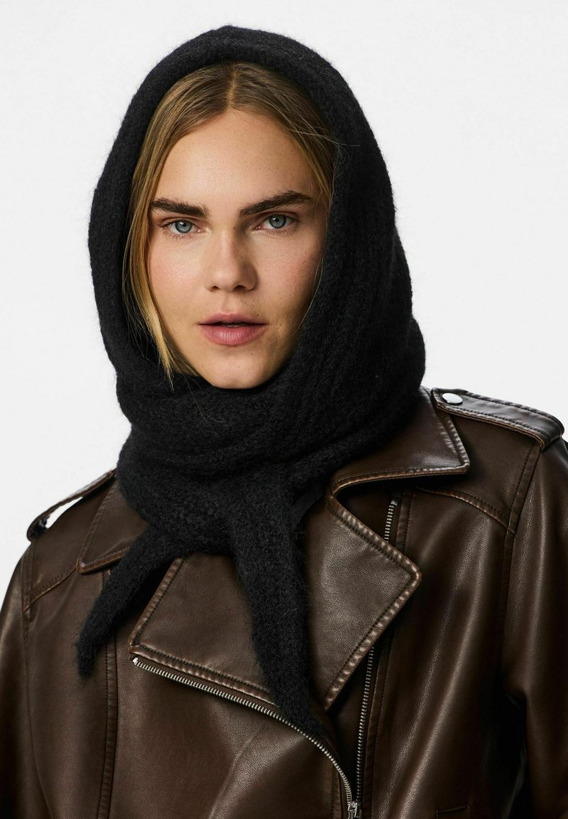 Scarf di lana nera avvolto attorno alla testa e al collo, con una finitura testurizzata. Abbinato a un giubbotto di pelle marrone con cerniere e rever.