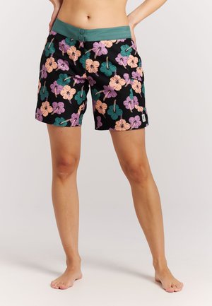 Zwarte korte broek met een kleurrijk hibiscus bloemenpatroon in paars, roze en groen. Heeft een groene tailleband met twee knopen.