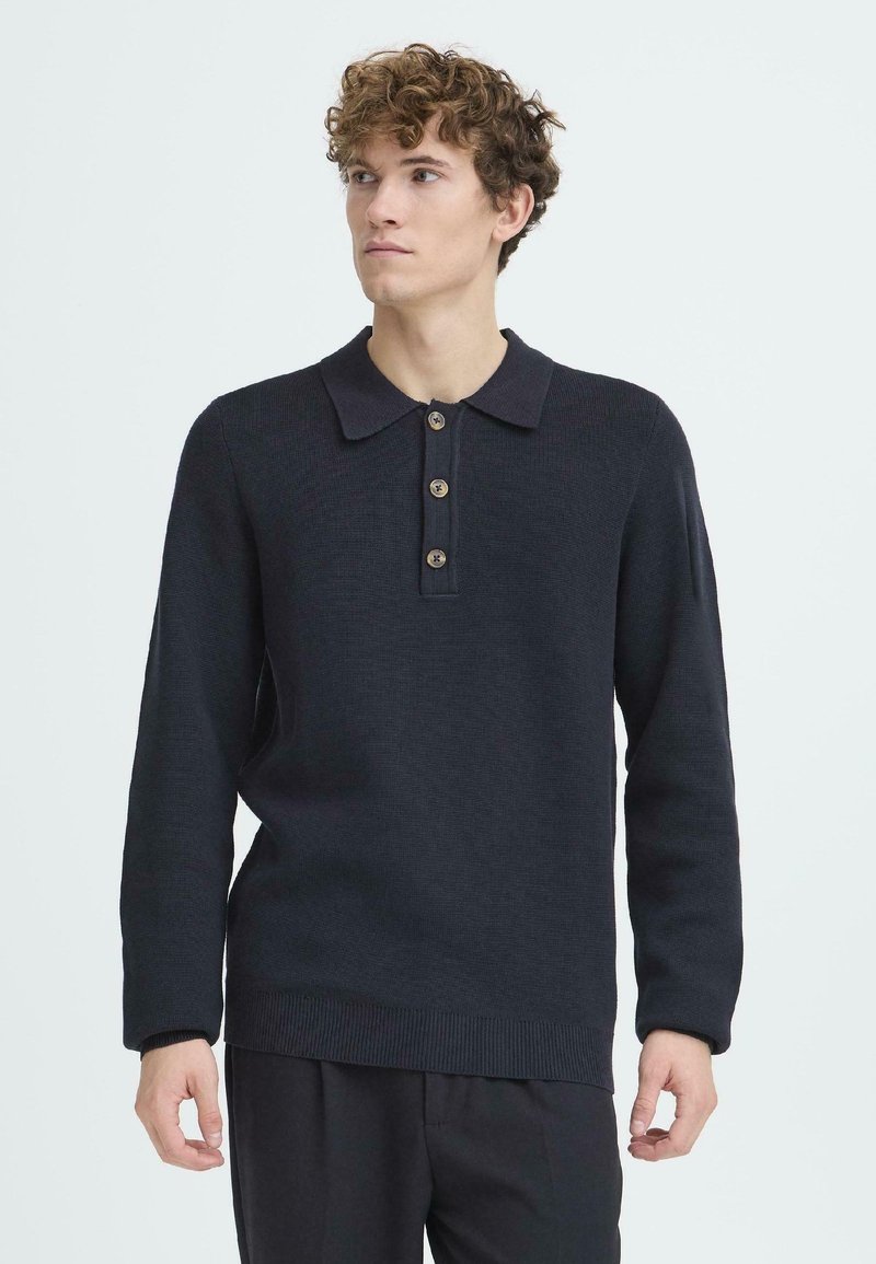 Dunkelblaues langärmliges Polo-Sweatshirt aus strukturiertem Strickstoff. Mit Kragen und Knopfleiste mit vier Knöpfen. Gerippter Saum und Bündchen.