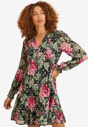 Rochie florală cu un fundal negru, cu modele roz și verzi, mâneci lungi, decolteu în V și volane la tiv. Material ușor.