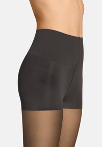 Durchsichtige schwarze Strumpfhosen mit hohem Bund, die oben aus weichem, blickdichtem Material bestehen und in einen durchsichtigen Bereich übergehen, der einen hautfarbenen Farbton hat.