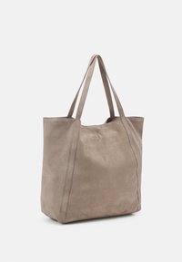 Suede torba u svijetloj taupe boji, s dva čvrsta ručka i vidljivim šavovima duž šavova, s glatkom, mekanom teksturom.