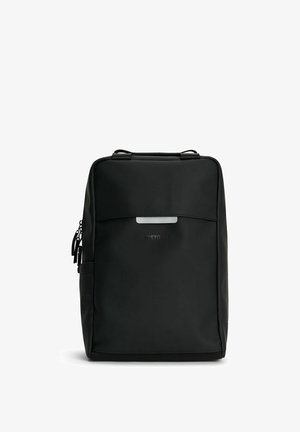 Svart ryggsäck tillverkad av slätt, vattentåligt material. Har en framfick med dragkedja, handtag upptill och en diskret logotyp. Platt, rektangulär form.