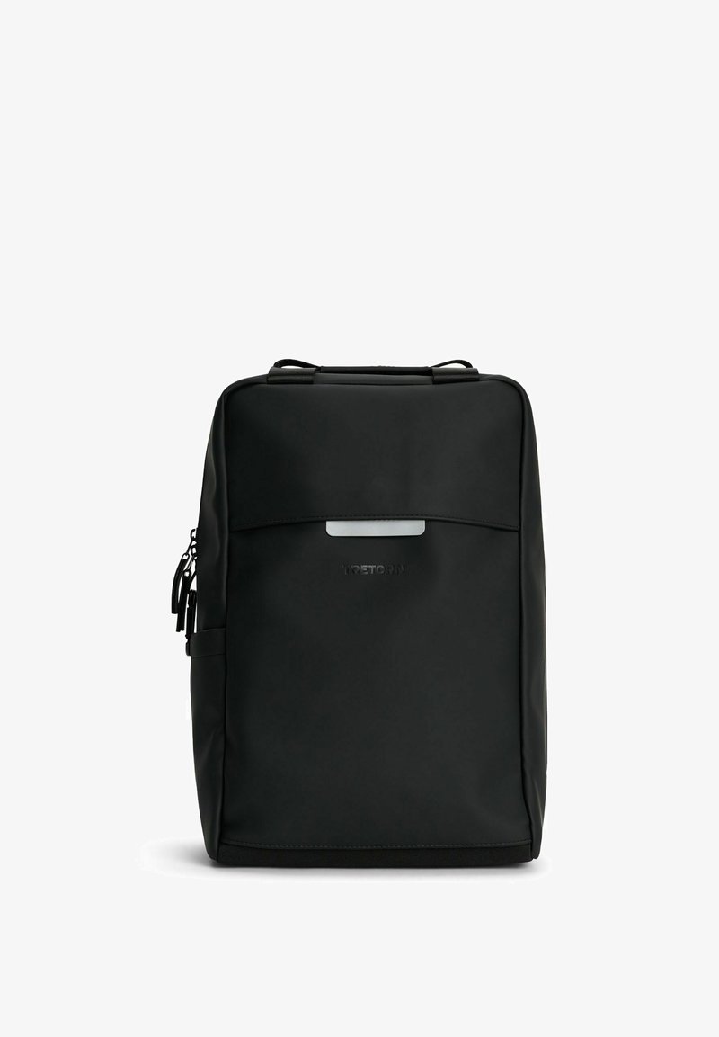 Sort rygsæk lavet af glat, vandafvisende materiale. Har en frontlomme med lynlås, top-håndtag og en diskret logo. Flad, rektangulær form.