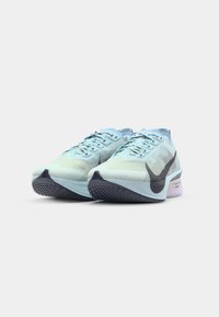 Baskets de course bleu clair avec une tige texturée, un logo swoosh noir, et une semelle rembourrée avec une accent violet et un motif de semelle.
