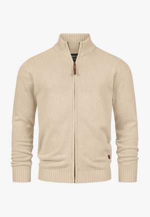 Beige rits cardigan met een hoge ribgebreide kraag en aansluitende mouwen. Heeft een zachte breistructuur en een klein leren logo-detail aan de zoom.
