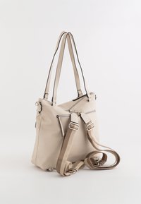 Sac fourre-tout en cuir beige avec deux poignées, matériel en argent, et plusieurs poches zippées. Inclut une bandoulière amovible rayée.