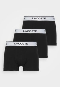 Black cotton boxer briefs with a white Lacoste logo waistband. Features a fitted design and a smooth texture. Pack of three.