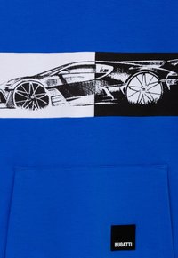 Maglietta blu con una grafica bianca e nera di una auto sportiva sul petto; include una tasca anteriore con un'etichetta nera "BUGATTI".