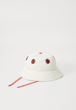 Cappello a secchiello in cotone di colore bianco sporco, con ricami di coccinelle rossi e neri. Include cordini regolabili rossi.