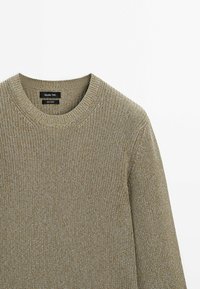 Beige gestrickter Baumwollpullover mit geripptem Rundhalsausschnitt und langen Ärmeln, der ein dezentes strukturiertes Muster aufweist.