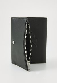 Black leather wallet with embossed logo, featuring a silver zipper on one edge and a snap button closure. Smooth texture, rectangular shape.