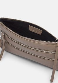 Borsa clutch in pelle beige con molteplici compartimenti con zip e cinturino da polso staccabile. Interno in tessuto nero con etichetta brandizzata.