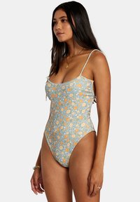 Floral-print one-piece swimsuit in light blue with orange and white flowers. Adjustable thin straps, scoop neckline, and textured fabric.