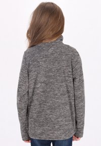Maglia grigia a maniche lunghe realizzata in un morbido tessuto testurizzato, con collo alto e una vestibilità leggermente ampia, mostrata da dietro.
