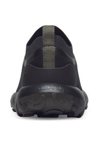 Scarpa sportiva nera con suola in gomma nera testurizzata e un'asola elastica verde sul tallone. Il materiale superiore liscio presenta un design minimalista.