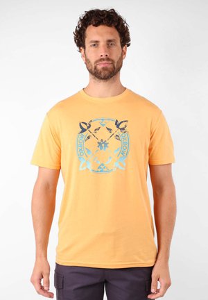 T-shirt à manches courtes en coton jaune vif avec un design graphique bleu comportant du texte et des motifs centrés sur la poitrine. Coupe classique.