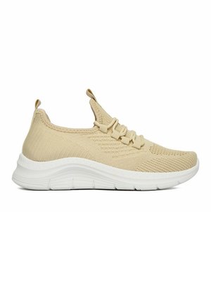 Beżowy dzianinowy sneaker z białą fakturowaną podeszwą, wsuwany, z elastycznymi sznurowadłami oraz pętelkami na języku i pięcie.
