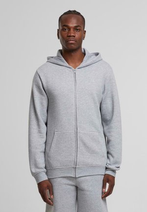 Grauer Reißverschluss-Hoodie aus weichem, gebürstetem Stoff. Mit einer Fronttasche, verstellbarem Kapuze und enganliegenden Bündchen. Passt gut zu grauen Sweatpants.