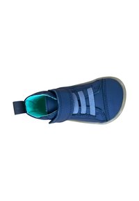 Zapato azul marino con una superficie lisa, cordones elásticos y una correa de velcro. Forro interior en un tono azul verdoso claro, con punta redondeada y suela de goma.