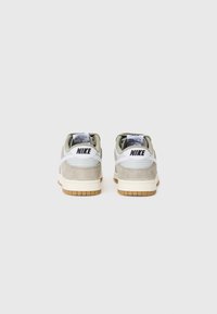 Nike sneakers med en lys grå ruskindsoverdel, hvide læderdetaljer og en gummirubber sål. Klassisk lav-top design med branding på hælen.