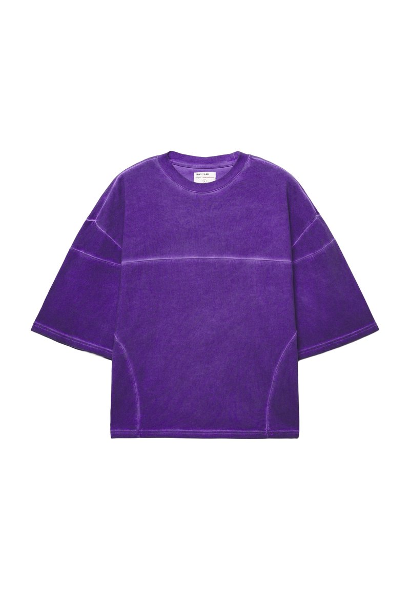 T-shirt viola oversize con maniche corte, realizzata in cotone, con una finitura testurizzata e dettagli di cucitura a contrasto.