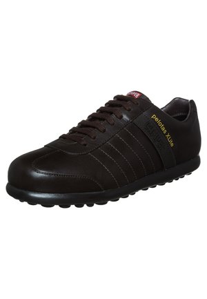 Black leather sneaker with tonal stripes, featuring a rubber sole, lace-up design, and yellow and red branding accents.