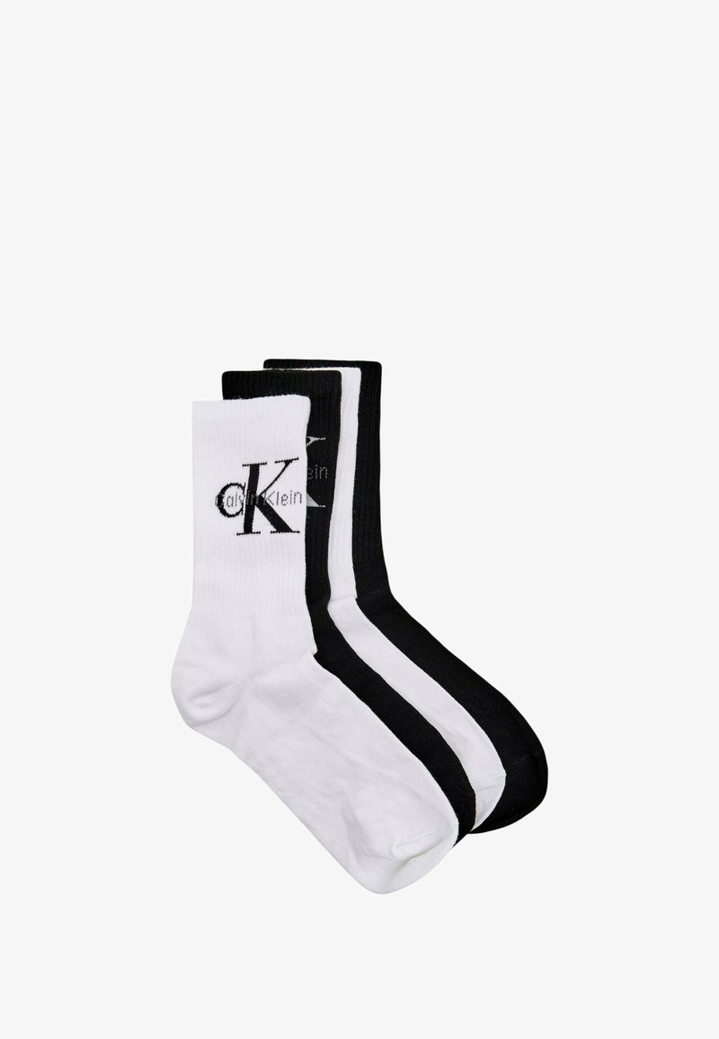 Tre paia di calzini da equipaggio in misto cotone: uno bianco con logo nero, uno bianco con strisce nere e uno completamente nero con logo.