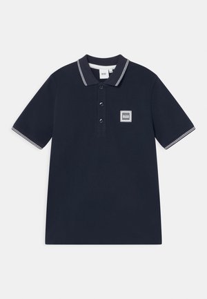 Polo bleu marine à manches courtes avec col et manches rayés blancs, patte à trois boutons et petit écusson logo sur la poitrine.