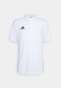 Polo blanc avec col classique, manches courtes et logo Adidas noir sur le côté gauche. Texture lisse et coupe régulière.