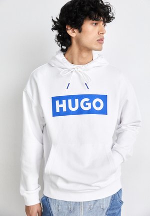 Balta vilna su mėlynu stačiakampiu logotipu "HUGO" priekyje. Yra su šnureliu reguliuojamu gobtuvu ir kengūros kišene. Patogi medžiaga ir laisvas kirpimas.
