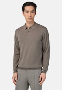 Polo s dolgimi rokavi v umirjeni taupe barvi, s rebrastim ovratnikom, zapenjanjem na tri gumbe in teksturiranim pletenim materialom.