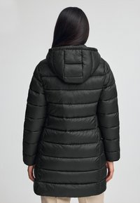 Czarna kurtka puchowa z kapturem, z poziomymi pikowaniami, gładką fakturą i elastycznymi mankietami.