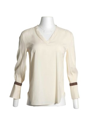 Blusa crema de manga larga con escote en V y bandas decorativas marrones sobre los puños, mostrada en un torso de maniquí blanco.