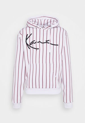 Sweat à capuche blanc avec des rayures verticales bordeaux, poche avant et capuche à cordon. Logo en script noir sur la poitrine. Matière en coton.